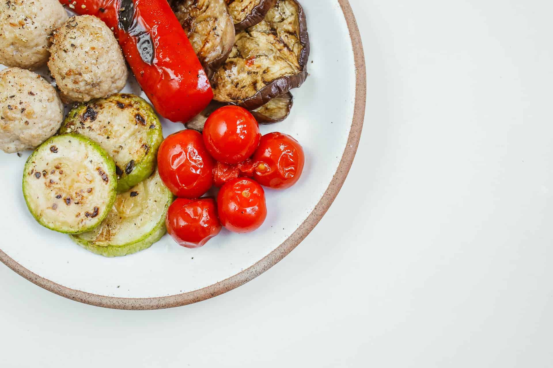 pexels-polina-tankilevitch-5419340 - RIM Digital Grilled vegetables (zucchini, pepper, eggplant) and meatballs with cherry tomatoes on a white plate.